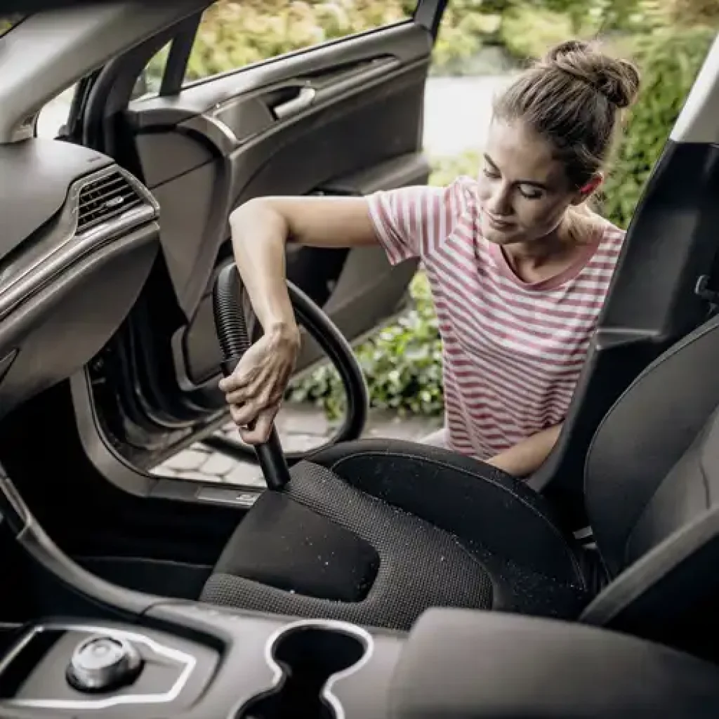 mujer aspirando un carro con Kärcher WD 2 Plus